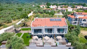 A modern hotel with a rooftop garden, multiple balconies, and a view of the surrounding countryside. - Valen Mare Suites (Thasos)