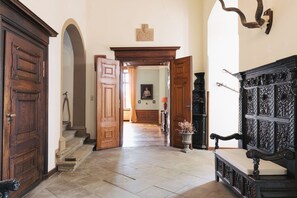A hallway with wooden doors, a fireplace, and a bench. - Gemünden Castle with pool. Paradise for hikers! (Gemünden)
