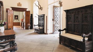 A spacious hallway with a dark wooden bench, a white vase with flowers, and a wooden door with intricate carvings. - Gemünden Castle with pool. Paradise for hikers! (Gemünden)
