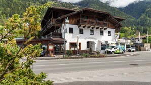 A two-story building with a sign reading 'APPARTMENTS' and a parked van in front. - Apartment Azalea – Arrive, Feel at Home, Discover the Ötztal – Comfort in Central Oetz (Oetz)