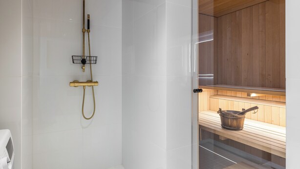 A modern bathroom with a shower, a wooden bench, and a sauna area. - Nordic Design with Sauna in Cental Helsinki (Kamppi) (Helsinki)