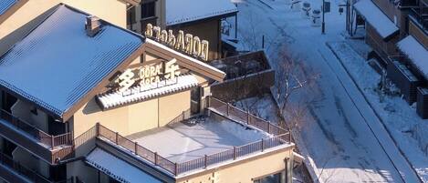 A multi-story building with a snow-covered roof and a sign that reads "Chagge Coffee."