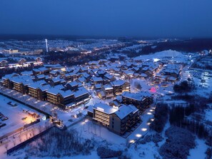 A snow-covered resort with multiple buildings, including a prominent lodge with a sign. - Doradora Boutique Hotel (Yanbian)