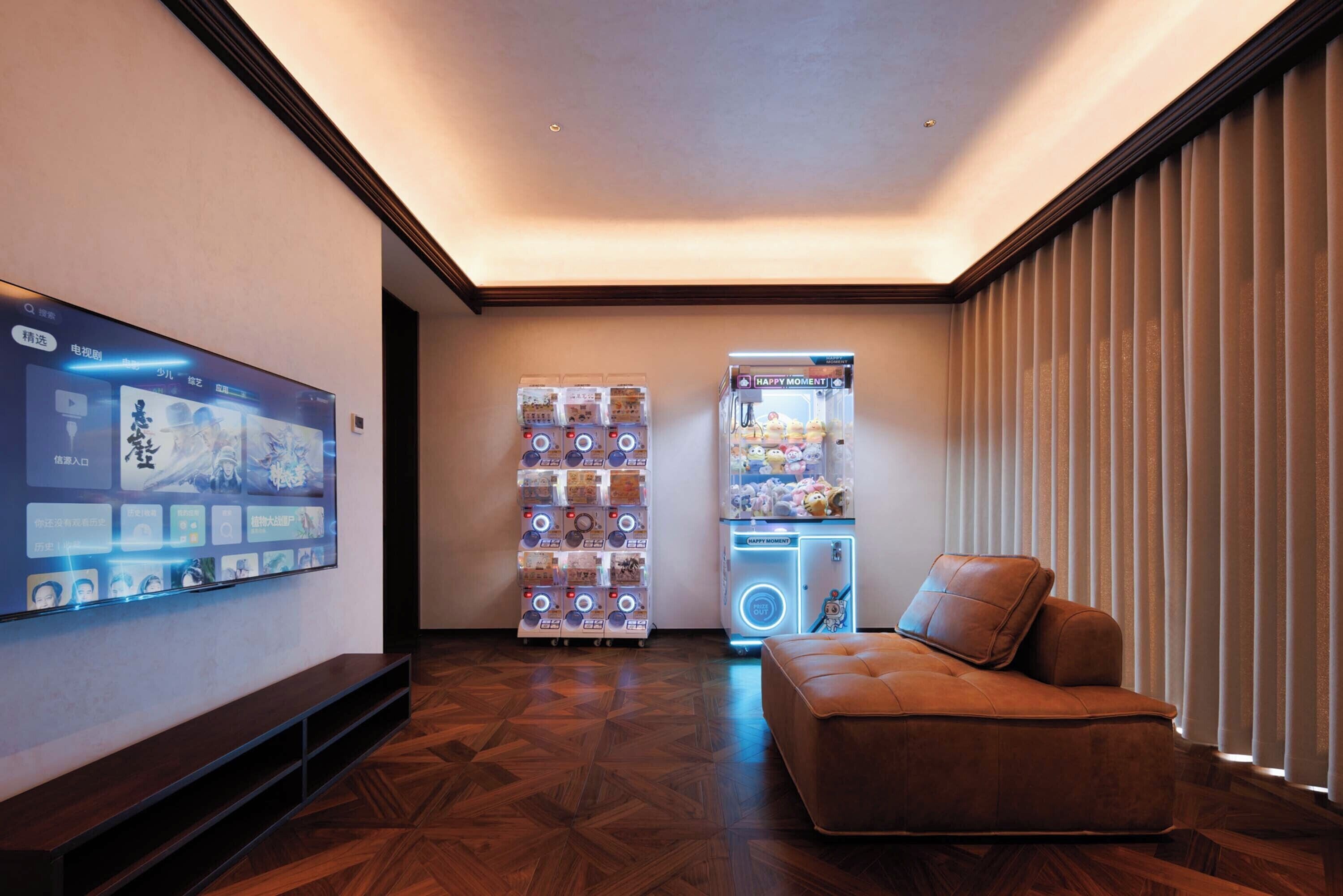 Un intérieur moderne avec un téléviseur à écran plat, des distributeurs automatiques et un canapé en cuir.