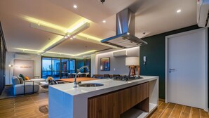 A modern kitchen with a central island, built-in cabinets, and a stainless steel sink. - Jsmart Studio #1106 - Comfortable apt by Carpediem (Fortaleza)