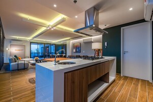 Una cocina moderna con una isla central, armarios empotrados y un lavamanos de acero inoxidable.