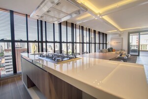 Una cocina moderna con una isla grande, ventanas amplias y vista a la ciudad.