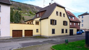 Un immeuble résidentiel doté d’un toit en pente, d’un garage et d’une allée.