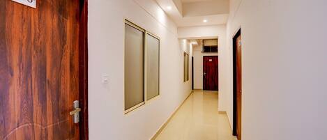 A hallway with a wooden door labeled '206', a sliding glass door, and a red door at the end.