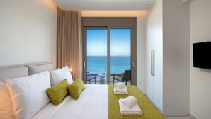 A hotel room with a bed, a balcony with a view of the sea, a TV, and a minibar. - Elounda Infinity Blue Luxury Villas (Agios Nikolaos)