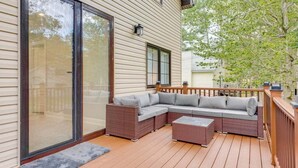 A covered deck with a sectional sofa and a small table, wooden railings, and a glass door leading to a covered patio. - 5br Villa Rose Near Tobyhanna State Park 5 Bedroom Villa (Tobyhanna)