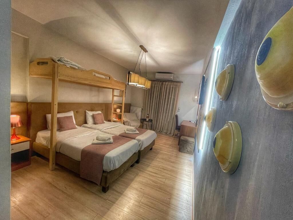 A room with bunk beds, a desk, a chair, and a wall with decorative plates.