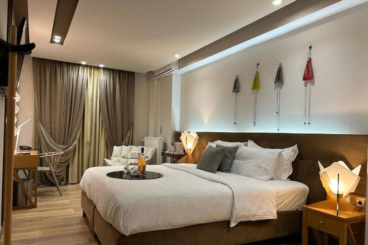 Une chambre d’hôtel moderne avec un grand lit, des tables de chevet, un bureau et une chaise.