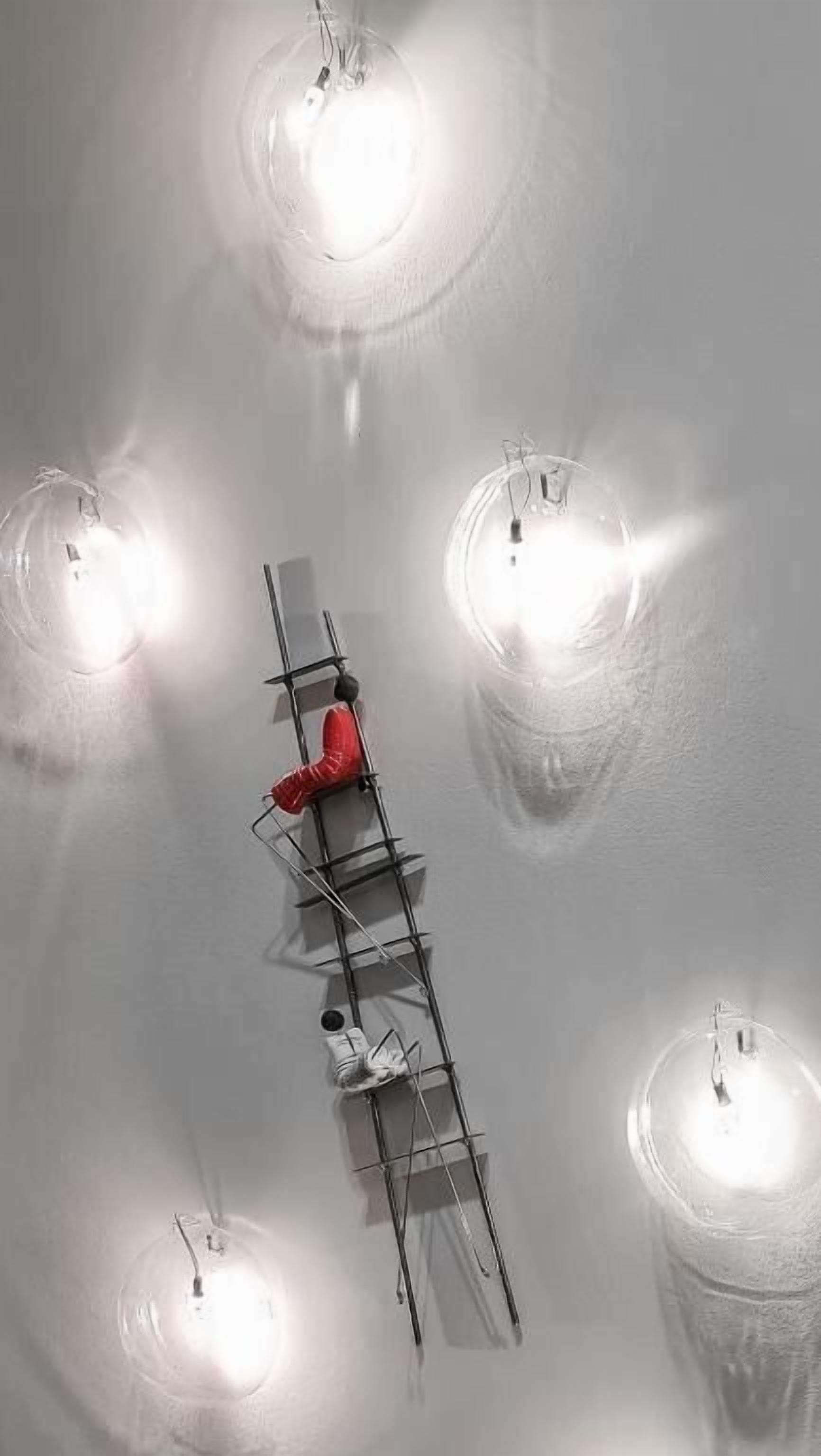 Uma pessoa escalando uma escada em um quarto com quatro luminárias.
