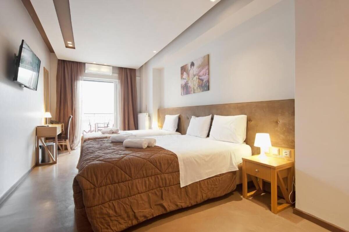 Une chambre d’hôtel avec un grand lit, un bureau, une chaise, une télévision et un tableau au mur.