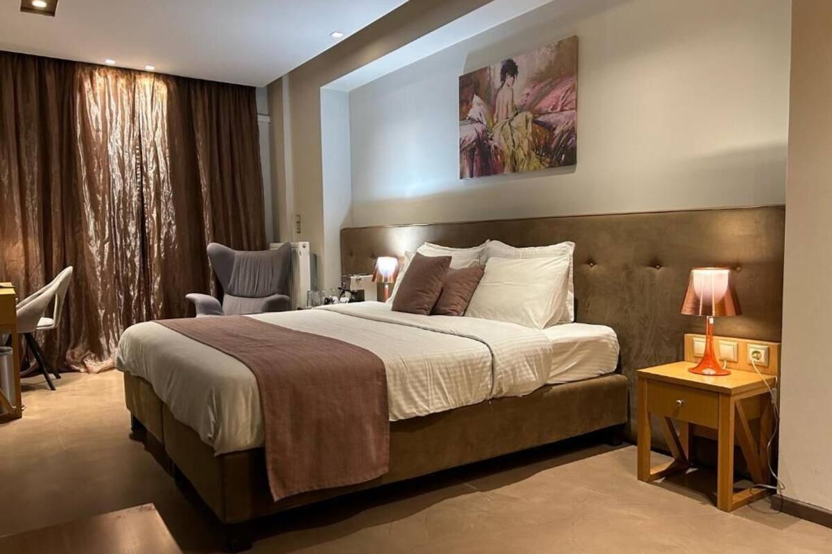 Une chambre à coucher avec un grand lit, une chaise, un bureau et une lampe.