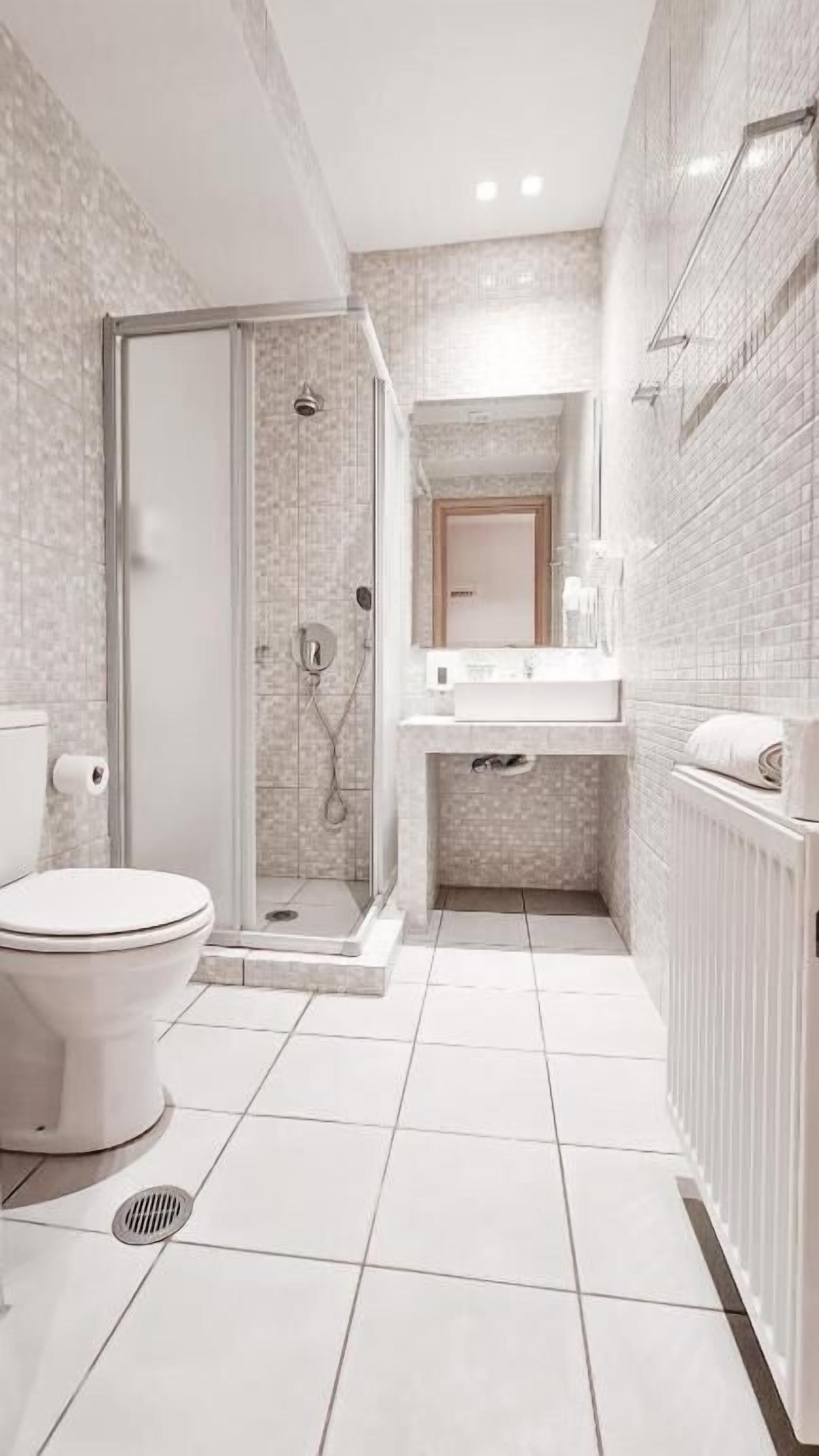 A modern bathroom with a toilet, shower, and sink.