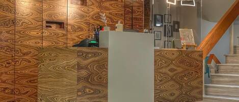 A reception area with a modern design, featuring a patterned wall and a reception desk.