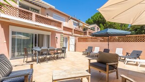 A patio with outdoor furniture, a table, and a chair. - Courtille Plage – Natural Retreat by the Sea in Fréjus (Fréjus)