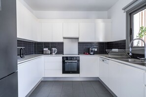 Appartement, uitzicht op tuin | Privékeuken | Een koelkast, een microgolfoven, een oven, een kookplaat