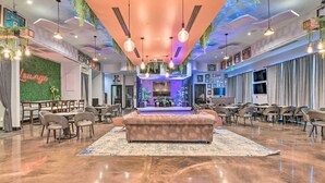 A spacious lounge area with a central seating area, multiple tables, and chairs. - Palms of Destin Condo w/ Lagoon Pool (Destin)