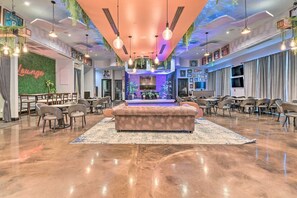 Ein geräumiger Lounge-Bereich mit einer zentralen Sitzecke, mehreren Tischen und Stühlen.
