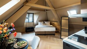 Une chambre de style loft moderne, comprenant un lit, une fenêtre de toit, un coin repas et une kitchenette.