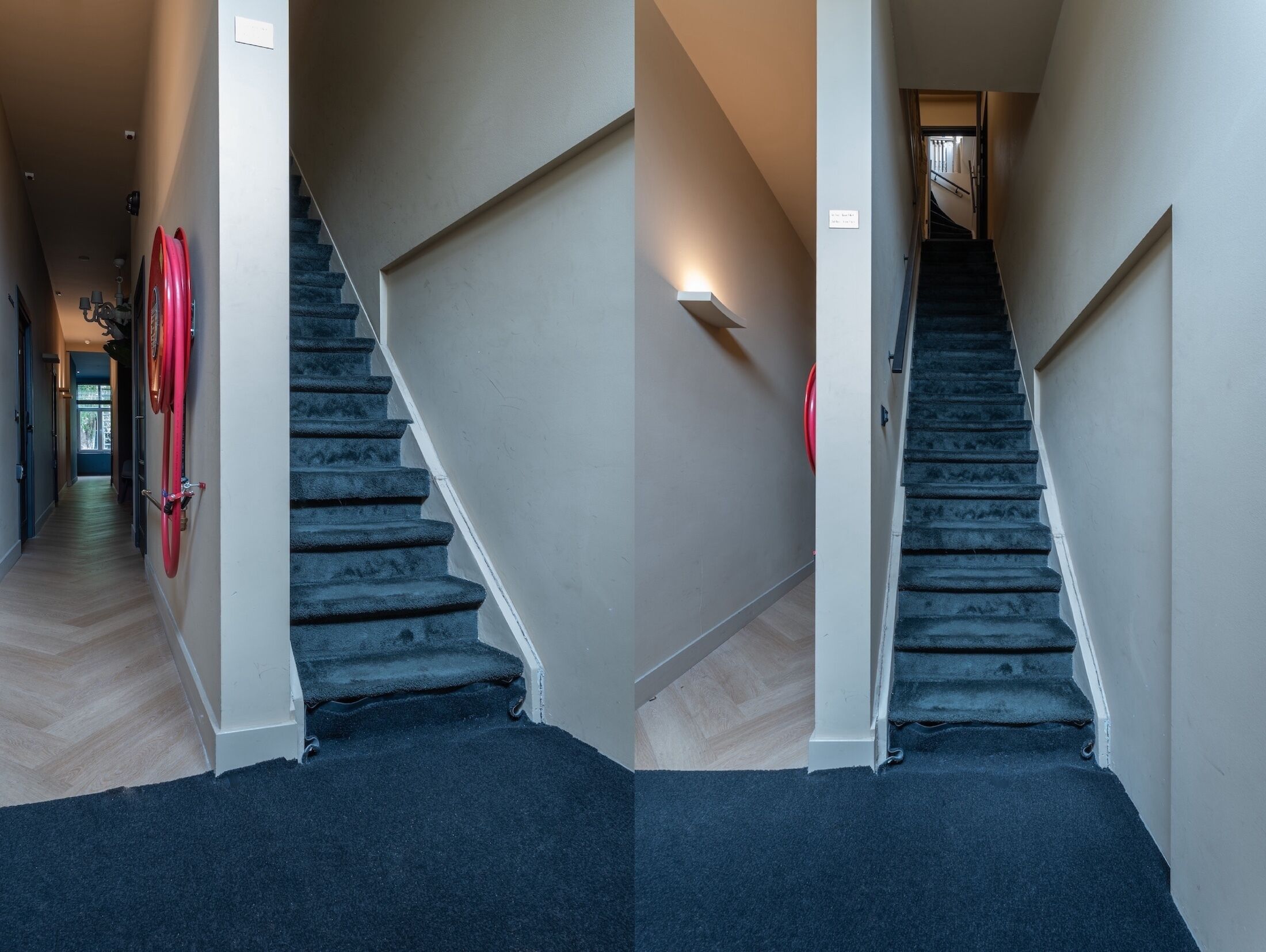 Una scala con pianerotto rivestito di moquette, corrimano e lampada a parete.