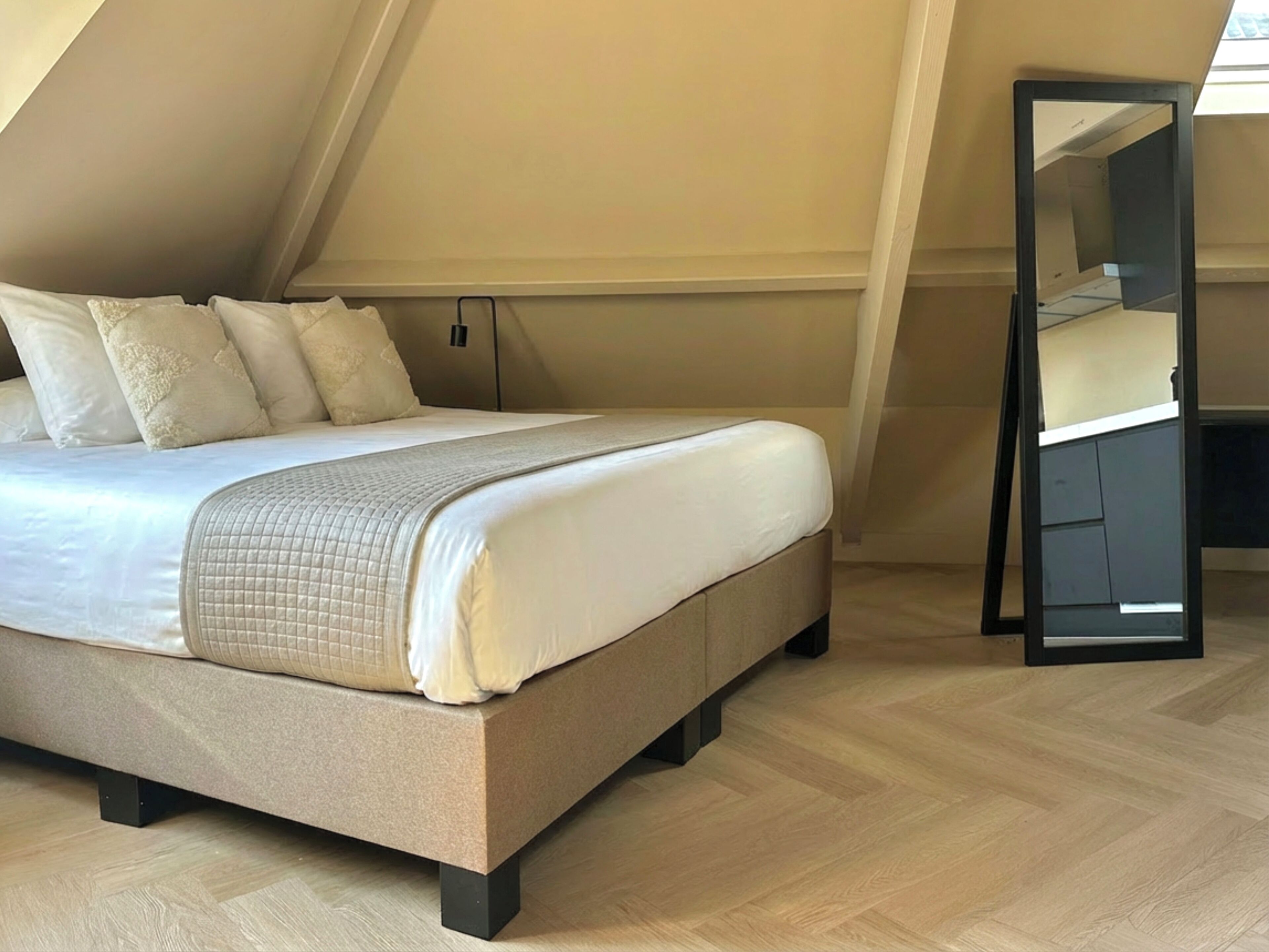 Un dormitorio con cama, armario y tragaluz.