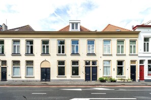 A row of townhouses with multiple windows, doors, and a visible street in front. - Just a few minutes walking from Breda’s city centre, with shops, cafés, restaurants, and nightlife nearby. Close to Breda Central Station. Explore the Grote Markt, enjoy Burgundian dining, and relax on lively terraces, all within walking distance. (Breda)