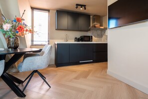 A modern kitchen with dark cabinets, a microwave, and a coffee maker on the counter. - Just a few minutes walking from Breda’s city centre, with shops, cafés, restaurants, and nightlife nearby. Close to Breda Central Station. Explore the Grote Markt, enjoy Burgundian dining, and relax on lively terraces, all within walking distance. (Breda)