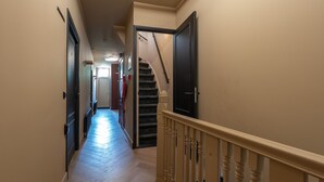 A hallway with a staircase, wooden flooring, and a beige wall. - Just a few minutes walking from Breda’s city centre, with shops, cafés, restaurants, and nightlife nearby. Close to Breda Central Station. Explore the Grote Markt, enjoy Burgundian dining, and relax on lively terraces, all within walking distance. (Breda)