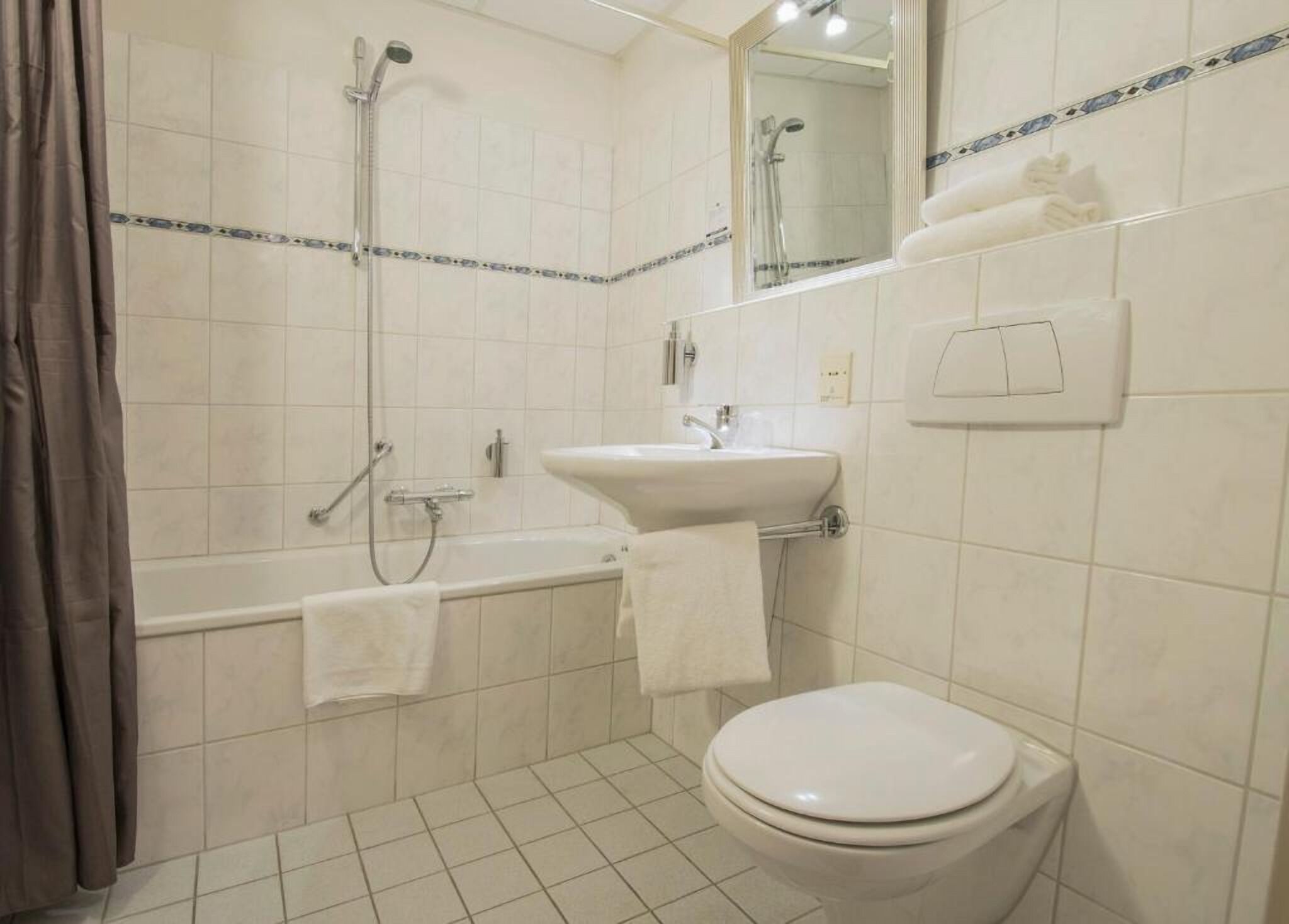 Een badkamer met een bad, een wastafel en een toilet.