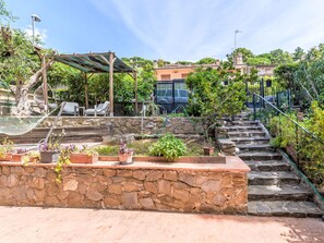 A stone staircase leading up to a wooden deck with outdoor furniture and potted plants. - Oleandro by Interhome (Castiglione della Pescaia)