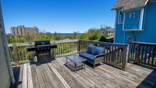 A wooden deck with a grill, a table, and a sofa. - Adorable Hilltop Cottage by the Beach (Michigan City)