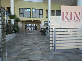 Una entrada imponente con un cartel que dice "RIN GRAND RESIDENCE".