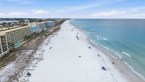 A beach with a hotel on the left, a pier in the distance, and a clear sky. - Gulf front home with shared pool, private balcony and beach access (Fort Walton Beach)