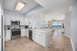 A spacious kitchen with white cabinetry, stainless steel appliances, and a large island. - 5th Floor Condo with Pools Onsite, Nearby Activities, Shops, Restaurants (Fort Walton Beach)