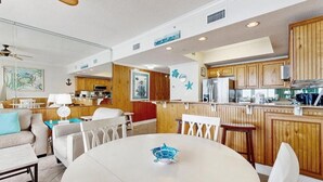 Une cuisine moderne avec des meubles en bois, un îlot central et un coin repas comprenant une table ronde et des chaises.