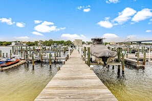Un muelle de madera que conduce a un puerto deportivo con barcos amarrados a muelles de madera.