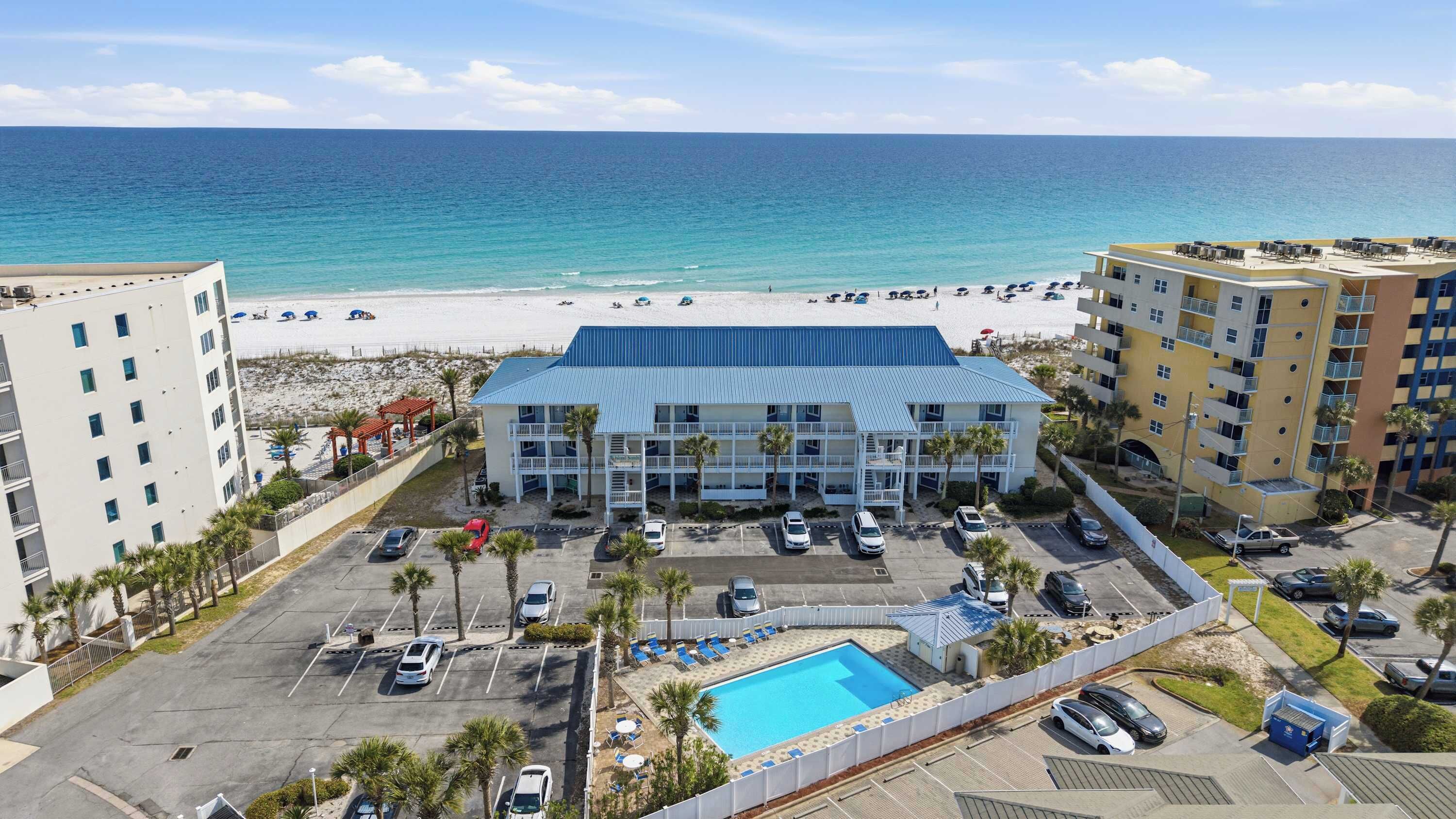 Un hôtel doté d'une piscine, offrant une vue sur la plage et disposant d'un parking.