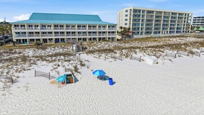 A beachfront hotel with multiple balconies, a pool area, and a sandy beach. - Beautiful beachfront condo with million-dollar views with Seasonal Beach Service and Beach Access (Fort Walton Beach)