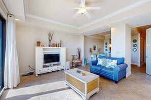 A living room with a television, sofa, and coffee table. - Stylish townhouse condo near the beach with full kitchen, WiFi, and shared pool (Santa Rosa Beach)