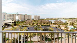 A hotel complex with multiple buildings, a parking lot, and a body of water in the background. - Seventh Floor Condo with Beach View Pool Gym and Private Balcony (Miramar Beach)