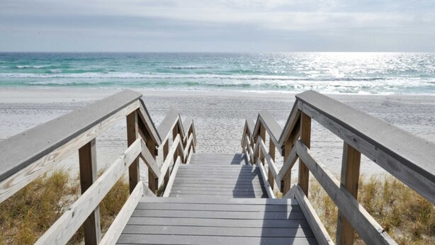 A wooden boardwalk leading to a beach with a clear view of the ocean. - Seventh Floor Condo with Beach View Pool Gym and Private Balcony (Miramar Beach)