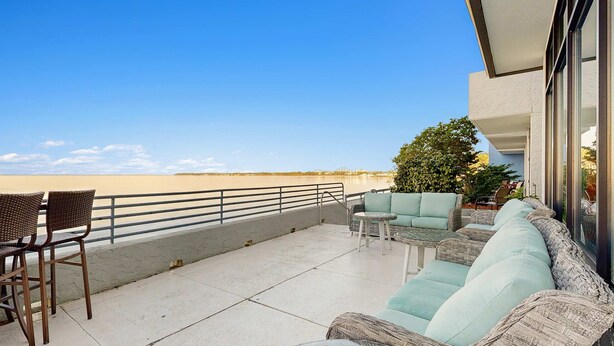 A balcony with a view of the beach, wicker furniture, and a railing. - Bayside Studio with nearby outlet shopping, Golf course and Community pool (Miramar Beach)