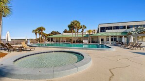 A pool area with multiple pools, lounge chairs, and palm trees. - Bayside Studio with nearby outlet shopping, Golf course and Community pool (Miramar Beach)