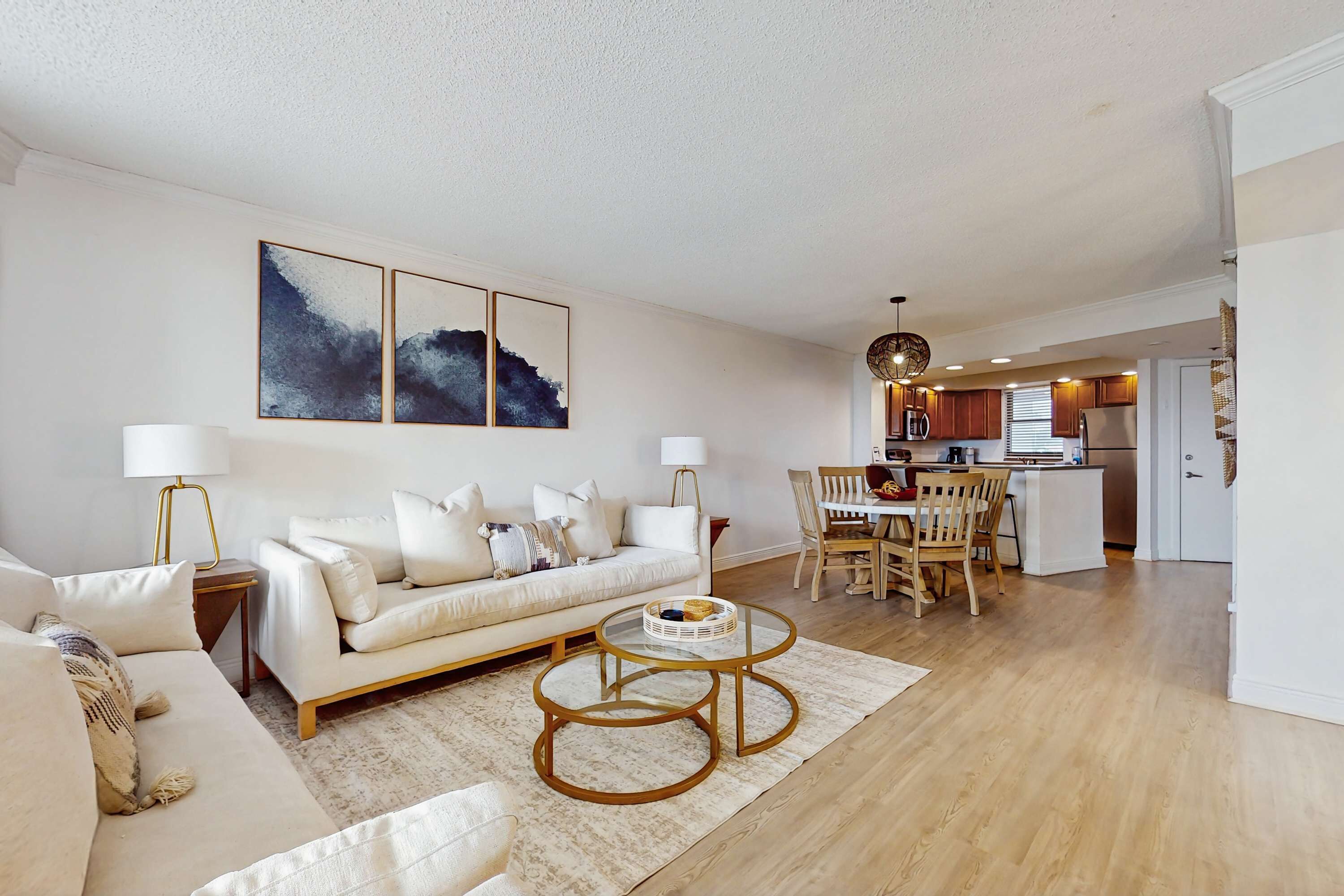 A modern living room with a sofa, coffee table, and artwork on the wall.