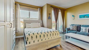 A bedroom with a bed, a sofa, a coffee table, and a painting on the wall. - Palm Court Yacht Club 312A - Third-floor cozy coastal studio with soundviews, WiFi, and shared pool & hot tub (Fort Walton Beach)
