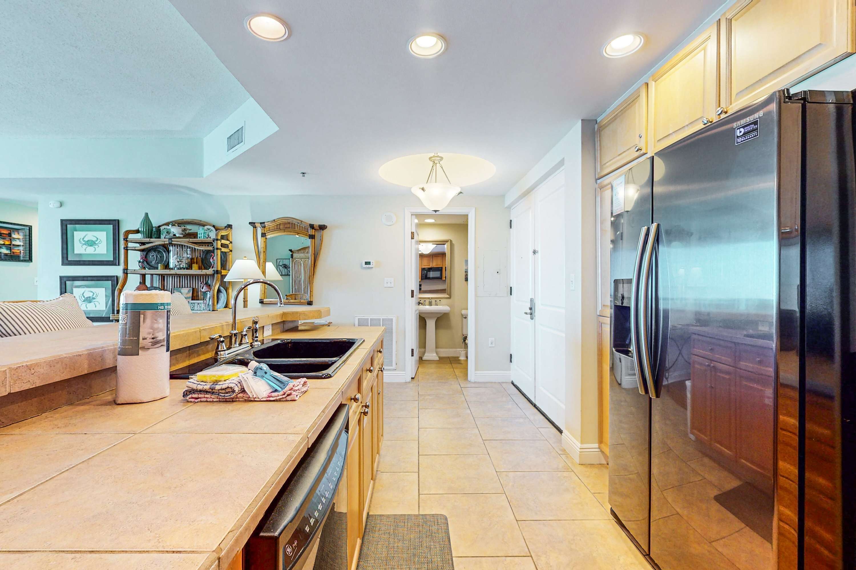A modern kitchen with a central island, stainless steel appliances, and a view into the dining area.